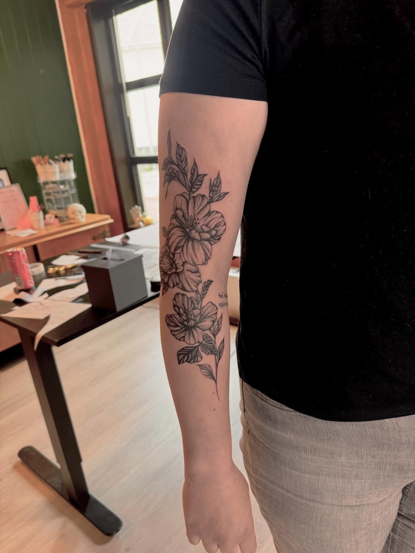 Blomsterkomposisjon i fine-line langs baksida av armen